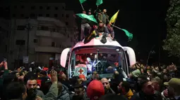 Sejumlah orang berkerumunan, bersorak, meneriakkan yel-yel dan membunyikan klakson mobil ketika dua bus yang membawa para tahanan tiba di Beitunia. (Zain JAAFAR/AFP)