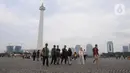 Warga berjalan-jalan di kawasan Monumen Nasional, Jakarta, Rabu (25/12/2019). Libur perayaan Natal 2019 dimanfaatkan warga Jakarta dan sekitarnya berwisata di Monumen Nasional. (Liputan6.com/Helmi Fithriansyah)