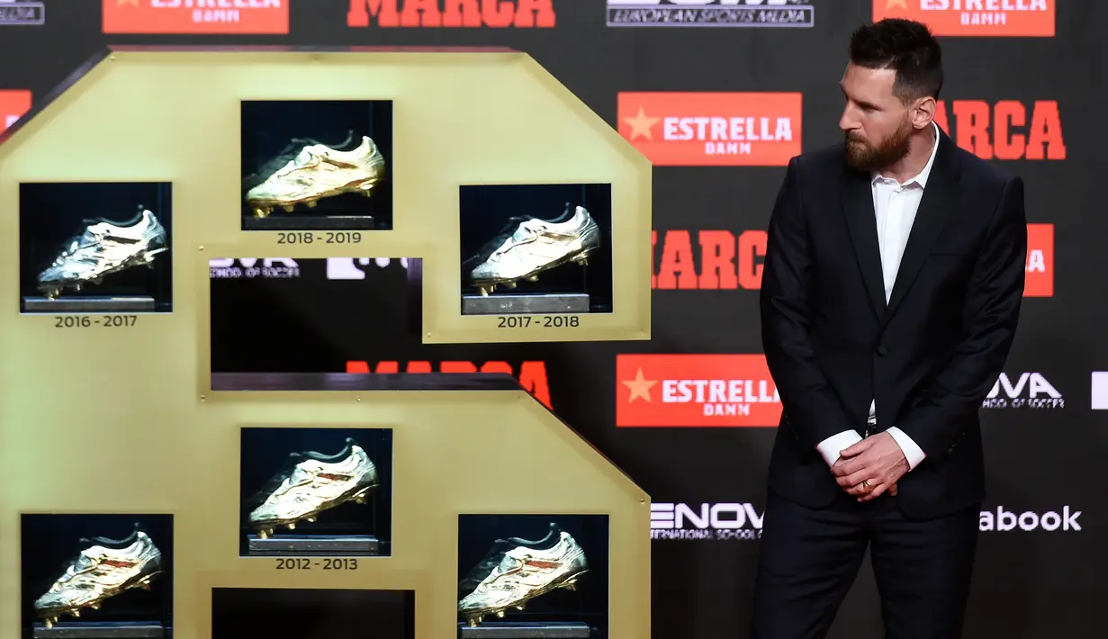 Pemain Barcelona, Lionel Messi melihat enam Sepatu Emas yang berhasil diraihnya di Antiga Fabrica Estrella Damm, Barcelona, Spanyol (16/10/2019). Bagi Messi Ini adalah tahun ketiga berturut-turut ia meraih penghargaan untuk gol terbanyak yang dibukukan pemain di liga utama. (AFP Photo/Josep Lago)