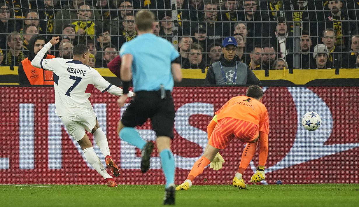 Pemain PSG, Kylian Mbappe (kiri) melepaskan tembakan setelah melewati kiper Borussia Dortmund, Gregor Kobel (kanan) pada laga lanjutan Grup F Liga Champions 2023/2024 di Signal Iduna Park, Dortmund, Jerman, Kamis (14/12/2023) dini hari WIB. (AP Photo/Martin Meissner)