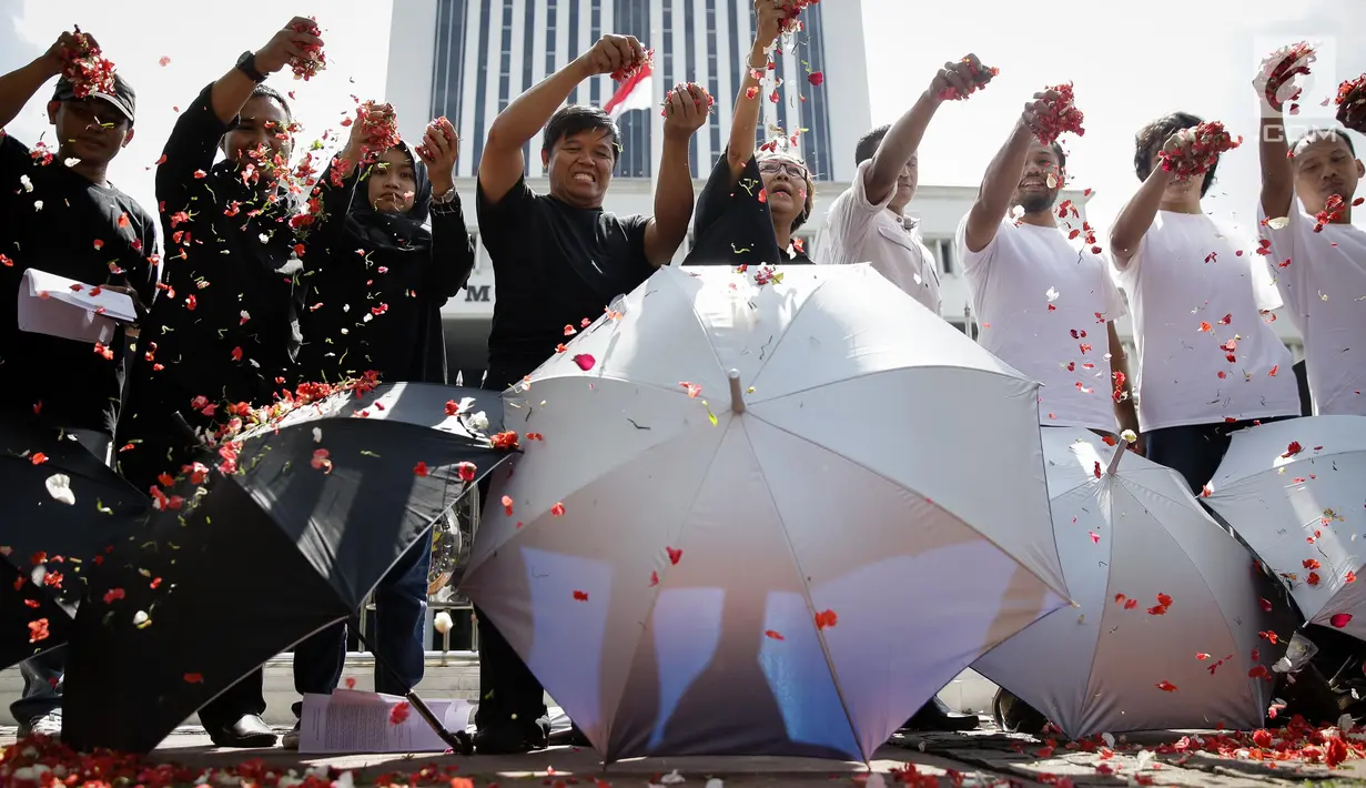 Sejumlah massa yang tergabung dalam Koalisi Masyarakat Sipil Penegak Citra DPD menaburkan bunga pada payung sebagai bentuk simbol kekhawatiran matinya keadilan dan penegakan hukum di depan Mahkamah Agung, Jakarta, Rabu (7/6). (Liputan6.com/Faizal Fanani)