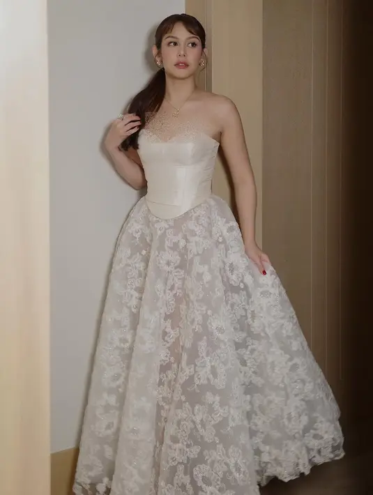 Pemeran Milea ini mengungkapkan rasa jatuh cintanya dengan pemutaran perdana The White Lotus di Bangkok. Vanesha tampil anggun dalam balutan gaun putih elegan dengan desain strapless dan korset di bagian atas. Roknya berbahan renda transparan dengan motif bunga yang menambah kesan mewah dan feminin. (Liputan6.com/IG/@vaneshaass)