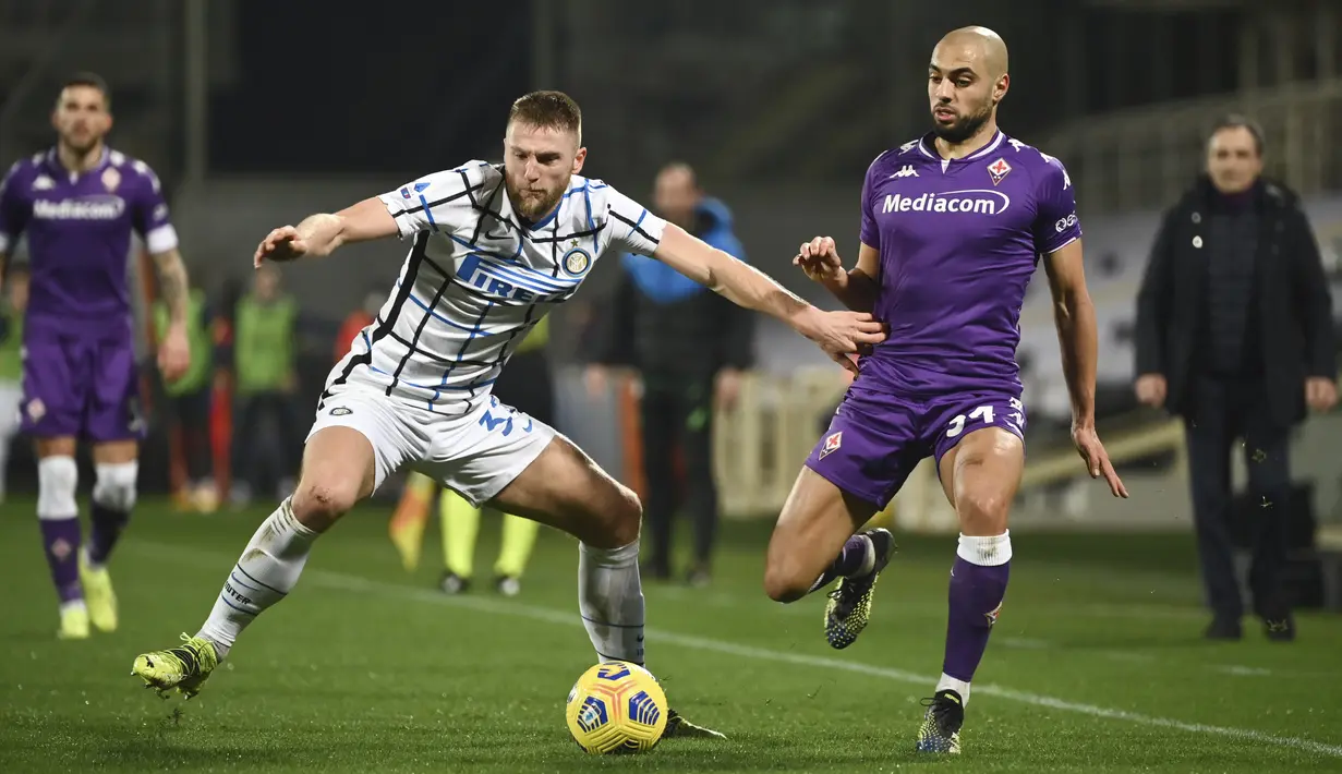 Gelandang Fiorentina, Sofyan Amrabat berebut bola dengan bek Inter Milan, Milan Skriniar pada lanjutan laga Liga Italia di Stadion Artemio Franchi, Sabtu dinihari WIB (6/2/2021). Inter mengalahkan Fiorentina 2-0 dan menggusur AC Milan dari puncak klasemen Serie A. (Massimo Paolone/LaPresse via AP)