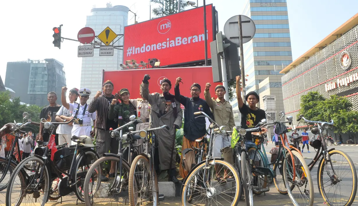 Sejumlah warga mengenakan atribut khusus melakukan aksi di sekitar lokasi Ledakan Thamrin, Jakarta, Minggu (17/1/2016). Mereka mengajak seluruh warga Jakarta untuk tidak takut pada teroris (Liputan6.com/Faisal R Syam)