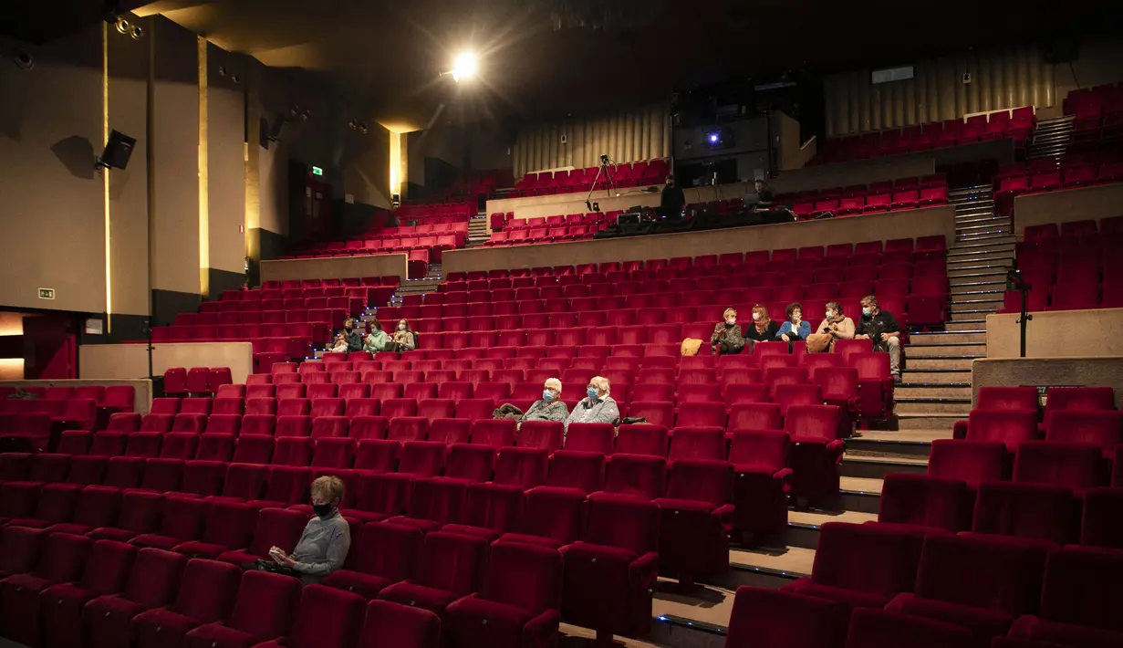 Orang-orang duduk untuk menonton sebuah pementasan di venue Centre Culturel di Brussels, Rabu (29/12/2021). Otoritas Belgia mengonfirmasi pembukaan kembali teater dan bioskop setelah pengadilan memenangkan gugatan dari sektor budaya terhadap penutupan venue-venue budaya. (HATIM KAGHAT/BELGA/AFP)