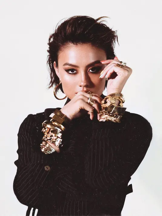 Agnez Mo dengan rambut pixie cut dan riasan wajah bold. Nuansa kecokelatan yang hangat sangat pas dengan outfit dan aksesori yang dikenakannya. Foto: Instagram.