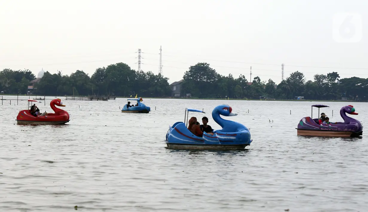 Warga menikmati wahana air di Danau Cipondoh, Kota Tangerang, Banten, Rabu (20/10/2021). Banyak warga memanfaatkan hari libur Maulid Nabi untuk berwisata bersama keluarga di kawasan tersebut sebagai alternatif wisata di tengah kota. (Liputan6.com/Angga Yuniar)