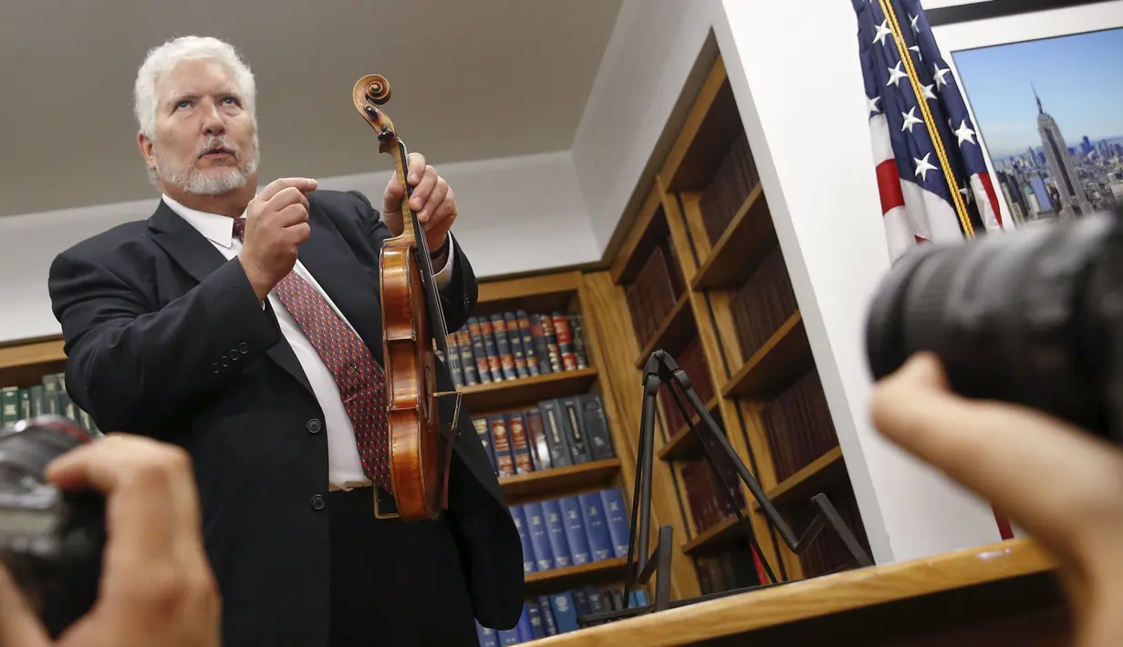 Ahli biola, Phillip Injeian menjelaskan biola Stradivarius pada konferensi pers di New York, Kamis (6/8/2015). Biola yang dibeli dengan harga Rp2,7 miliar itu kembali ke pemiliknya setelah hilang dicuri selama 35 tahun. (REUTERS/Shannon Stapleton)