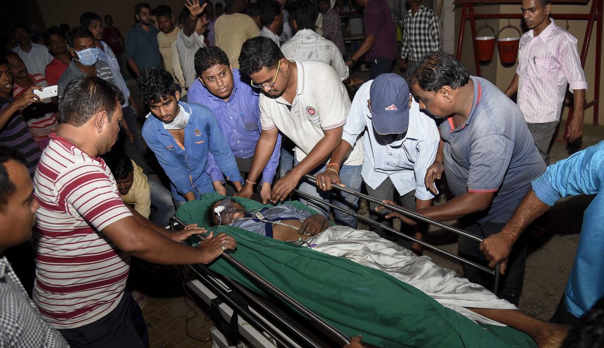 Petugas memindahkan korban ke rumah sakit lain saat kebakaran besar melanda rumah sakit SUM Bhubaneshwar di Odisha, India Timur, Senin (17/10). Sebanyak 120 petugas pemadam dikerahkan dan butuh waktu hampir dua jam untuk mengendalikan si jago merah. (AFP)