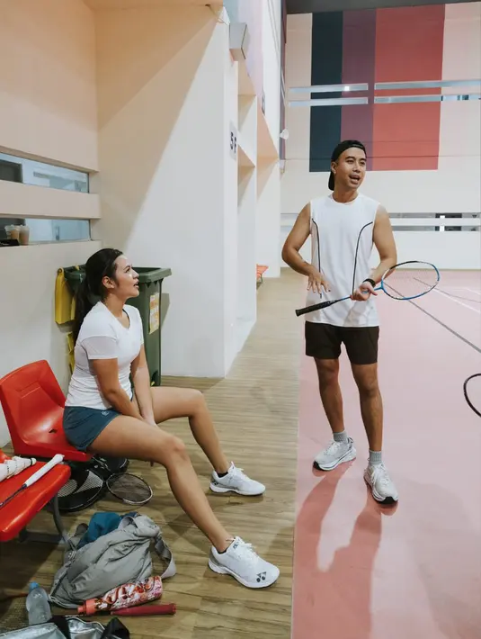 Vidi Aldiano dan Raisa kompak mengenakan t-shirt berwarna putih saat bermain bulu tangkis bersama. (Twitter/@vidialdiano)