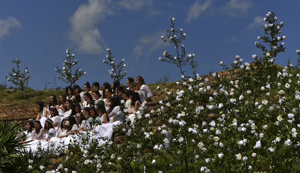 Las Doncellas (gadis) berpakaian putih dikelilingi oleh bunga saat ambil bagian dalam ziarah The Maidens di Sorzano, Spanyol, 15 Mei 2022. Menurut tradisi kuno, ziarah The Maidens bertujuan untuk menghormati musim semi dan kesuburan wanita. (AP Photo/Alvaro Barrientos)