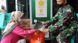 Warga menggunakan ATM Pertanian Si Komandan untuk mendapatkan beras gratis di Kodim 0606/Kota Bogor, Jawa Barat, Minggu (26/4/2020). Kementerian Pertanian bersama Bank BNI, dan TNI AD  menempatkan ATM beras gratis di sejumlah Kodim di wilayah Jabodetabek. (merdeka.com/Arie Basuki)