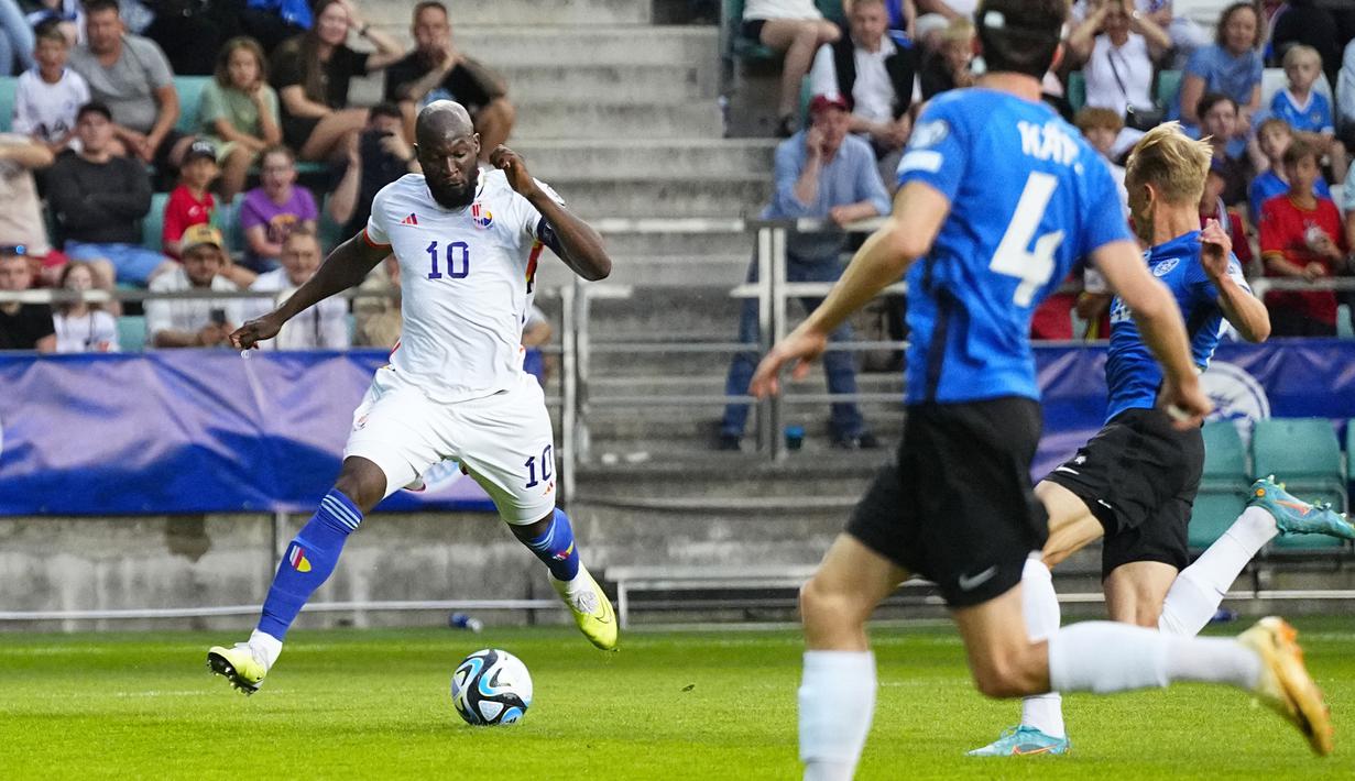 Pemain Belgia, Romelu Lukaku (kiri) berusaha melewati pemain Estonia pada laga Grup F Kualifikasi Euro 2024 yang berlangsung di A. Le Coq Arena, Tallinn, Estonia, Rabu (21/06/2023) dini hari WIB. Lukaku sukses mencetak dua gol untuk kemenangan 3-0 Belgia. (AP Photo/Pavel Golovkin)