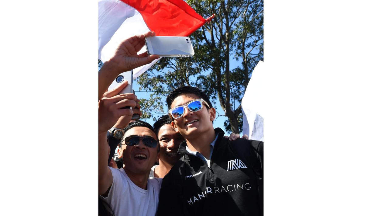 Antusias Fans Indonesia saat bertemu Rio Haryanto dan berfoto selfie bersama sebelum balapan perdana Formula One Australian Grand Prix, Melbourne, Minggu (20/3/2016). (AFP/Paul Crock)