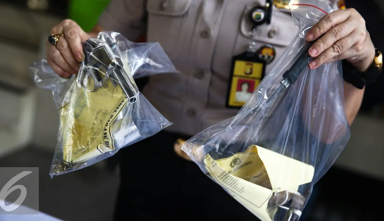 Petugas menunjukan barang bukti senjata api jenis revolver saat rilis di Jakarta, Jumat (26/8). Barang bukti 3 motor, 2 senjata tajam, 1 kunci leter T dan 2 senjata api rakitan jenis Revolver berserta peluru. (Liputan6.com/Faizal Fanani)  