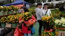 Warga Hong Kong berburu jeruk Mandarin untuk menyambut Tahun Baru Imlek di Victoria Park, Senin (4/2). (AP Photo/Vincent Yu)