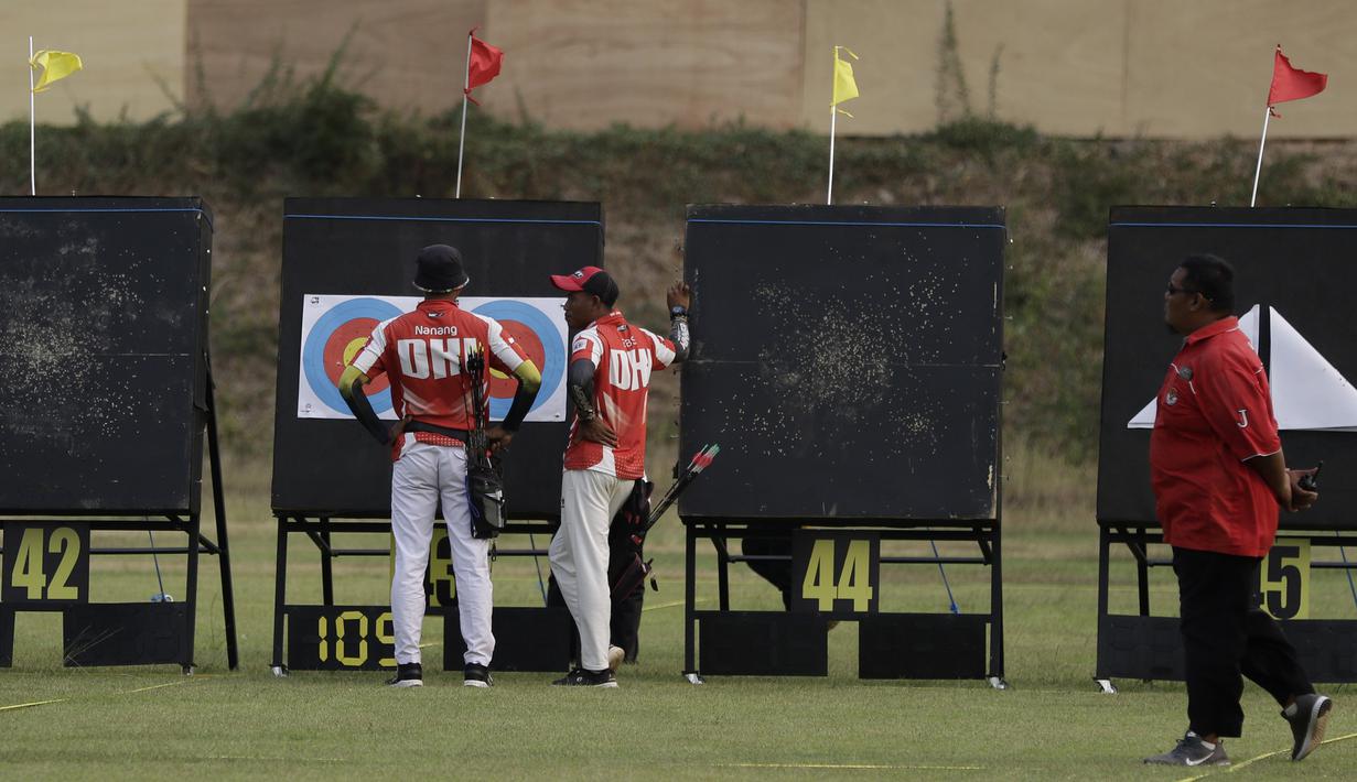Pepanah compound beregu putra DKI Jakarta melihat nilai sasaran saat Kejuaraan Nasional Panahan Prakualifikasi PON XX/2020 di Lapangan Panahan, Senayan, Jakarta, Selasa (24/9). Sebanyak 516 pepanah dari 30 provinsi bersaing untuk bisa lolos ke PON 2020 Papua. (Bola.com/Yoppy Renato)