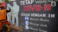 Petugas PPSU Kelurahan Bukit Duri menyelesaikan mural bertema Covid-19 di Jakarta, Selasa (11/8/2020). Mural tersebut untuk mengingatkan warga agar selalu waspada dengan Covid-19 dan mencegahnya dengan 3M (Memakai Masker, Menjaga Jarak dan Mencuci Tangan). (Liputan6.com/Faizal Fanani)