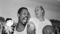 Bill Russell dari Boston Celtics&nbsp;(kiri) memegang korsase yang dikirim ke ruang ganti saat ia merayakan dengan pelatih Celtics Red Auerbach setelah mengalahkan Los Angeles Lakers 95-93 untuk memenangkan Kejuaraan NBA kedelapan berturut-turut di Boston, 29 April 1966. (foto:&nbsp;AP Photo/File)
