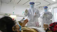 Petugas medis memeriksa kondisi pasien kritis virus corona atau COVID-19 di Rumah Sakit Jinyintan, Wuhan, Provinsi Hubei, China, Kamis (13/2/2020). China melaporkan 254 kematian baru dan lonjakan kasus virus corona sebanyak 15.152. (Chinatopix Via AP)