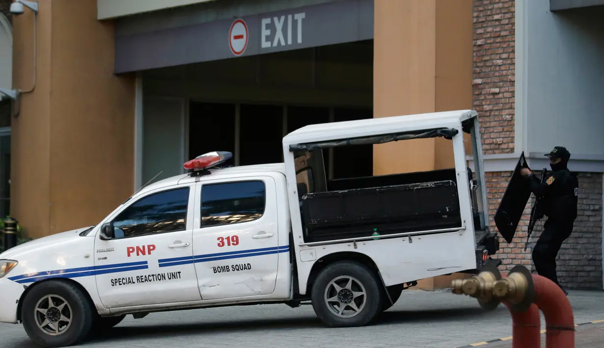 Petugas kepolisian memasukkan tameng pelindung ke dalam kendaraan di luar hotel Resorts World Manila, Filipina, Jumat (2/6). Seorang pria bersenjata ditemukan bunuh diri usai menyerang ruang kasino dengan beberapa kali tembakan. (AP Photo/Aaron Favila)