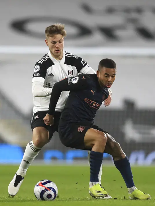 Pemain Fulham Joachim Andersenm (kiri) memperebutkan bola dengan pemain Manchester City Gabriel Jesus pada pertandingan Liga Inggris di Stadion Craven Cottage, London, Inggris, Sabtu (13/3/2021). Manchester City menang 3-0. (Adam Davy/Pool via AP)