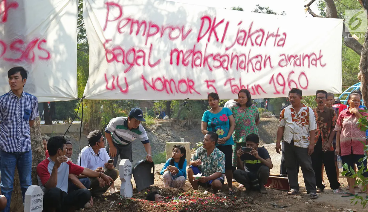 Warga yang tergabung dalam Aliansi Tanah Untuk Rakyat melakukan aksi kubur diri di Taman Kayu Mas, Pulogadung, Jakarta Timur, Jumat (23/8/2019). Mereka menuntu sengketa tanah antara warga dengan badan pertanahan DKI Jakarta diselesaikan. (Liputan6.com/Herman Zakharia)