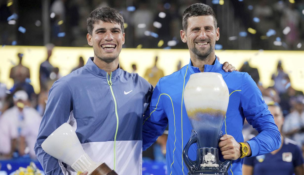 Petenis asal Serbia, Novak Djokovic, foto bersama petenis asal Spanyol, Carlos Alcaraz, saat selebrasi menjuarai ATP Cincinnati Open 2023 di Mason, Ohio (20/8/2023). Djokovic menang dalam laga sengit 5-7, 7-6(9/7), 7-6(7/4). (AP Photo/Aaron Doster)