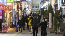 Orang-orang berjalan di sekitar lingkungan Shinjuku Tokyo, Kamis (7/1/2021). Keadaan darurat untuk Tokyo tersebut untuk memerangi peningkatan infeksi Virus Corona COVID-19. (AP Photo/Hiro Komae)