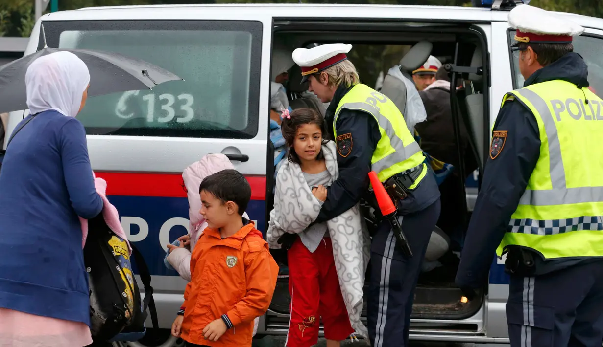 Polisi Austria membantu imigran saat tiba di stasiun Nickelsdorf, Austria, Sabtu (5/9/2015). Sekitar 2.000 imigran menembus Austria setelah pemerintah Hungaria mengizinkan para pencari suaka ke negara selanjutnya. (REUTERS/Heinz-Peter Bader)