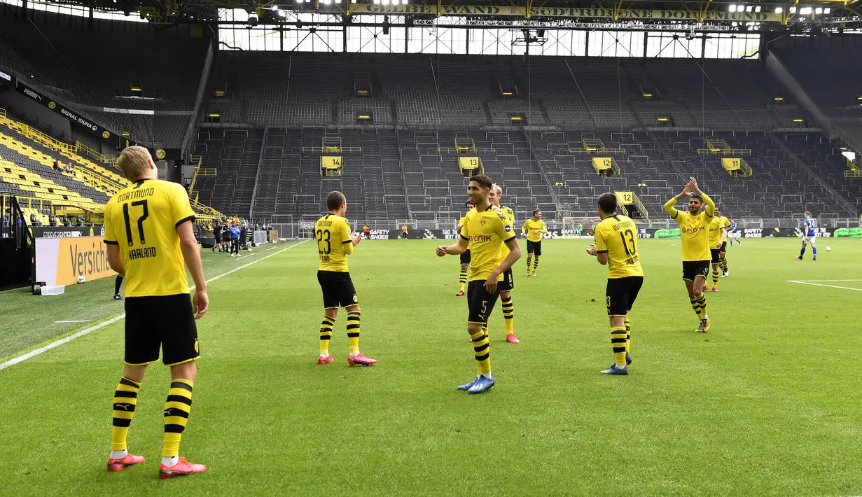 Para pemain Borussia Dortmund merayakan gol yang dicetak oleh Erling Haaland ke gawang Schalke 04 pada laga Bundesliga di Stadion Signal Iduna Park, Sabtu (16/5/2020). Pandemi COVID-19 membuat pemain melakukan selebrasi jaga jarak. (AP/Martin Meissner)