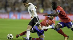 Pemain Argentina, Angel Di Maria melewati adangan dua pemain Haiti pada laga uji coba di Buenos Aires, Argentina, (29/5/2018). Argentina menang 4-0. (AP/Victor R. Caivano)