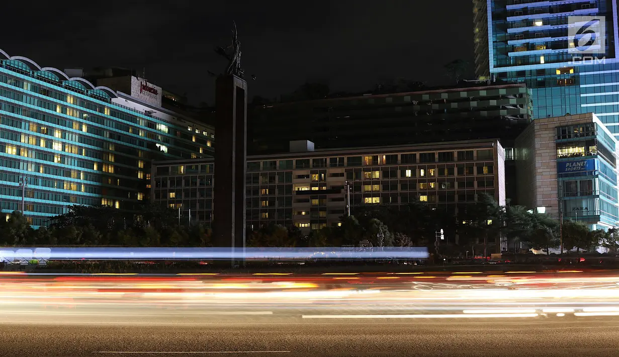 Suasana kawasan Bundaran HI saat lampu dipadamkan pada peringatan Earth Hour 2018 di Jakarta, Sabtu (24/3). Earth Hour dilakukan untuk efisiensi energi yang berdampak pada penanggulangan perubahan iklim. (Liputan6.com/Immanuel Antonius)
