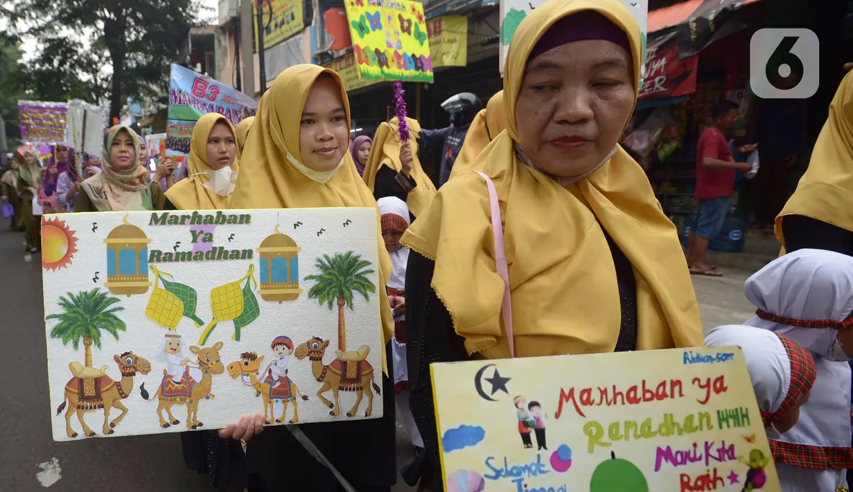 Orangtua murid TK Islam berjalan bersama sambil membawa poster di Jalan Raya Radjiman Widyo Ningrat, Jakarta, Sabtu (26/3/2022). Pemerintah telah memperbolehkan melaksanakan kewajiban selama bulan suci Ramadan dengan protokol kesehatan yang ketat. (merdeka.com/Imam Buhori)