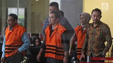 Tersangka anggota DPRD Malang Wiwik Hendri Astuti, M Zainudin dan Suprapto mengenakan rompi tahanan usai menjalani pemeriksaan di Gedung KPK, Jakarta, Rabu (28/3). 5 anggota DPRD Malang resmi ditahan atas dugaan suap APBD-P. (Liputan6.com/Herman Zakharia)