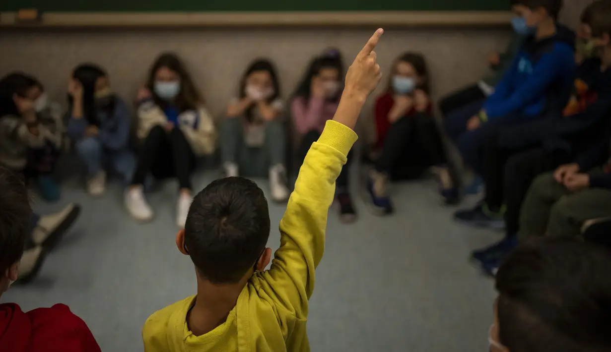 Siswa sekolah dasar melanjutkan kelas setelah liburan Natal di Barcelona, Spanyol, Senin (10/1/2022). Sekitar 8 juta siswa sekolah dasar dan menengah melanjutkan kelas setelah libur panjang Natal dan Tahun Baru meskipun ada prevelance yang mengkhawatirkan dari varian omicron. (AP/Emilio Morenatti)