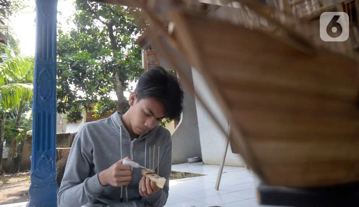 Perajin menyelesaikan pembuatan miniatur kapal pinisi yang terbuat dari limbah bambu di Pondok Benda, Pamulang, Tangerang Selatan, Senin (09/11/2020). Kerajinan berbahan bambu bekas yang dijual dengan harga berkisar Rp.50 ribu hingga Rp.250 ribu tergantung ukurannya. (merdeka.com/Dwi Narwoko)