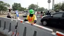 Petugas memasang penutup di Jalan Pramuka Sari IIi, Jakarta, Jumat (21/7). Uji coba pengalihan arus lalu lintas terkait pembangunan underpass Matraman dan berlangsung hingga 27 Juli mendatang. (Liputan6.com/Helmi Fithriansyah)