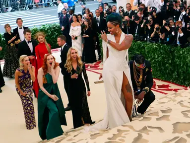 Rapper 2 Chainz berlutut saat sang kekasih, Kesha Ward memperlihatkan cincin pada Met Gala 2018 di Metropolitan Museum of Art, New York, Senin (7/5). Dalam acara Met Gala, Chainz melamar sang kekasih yang telah memberikannya dua putri. (AP/John Carucci)