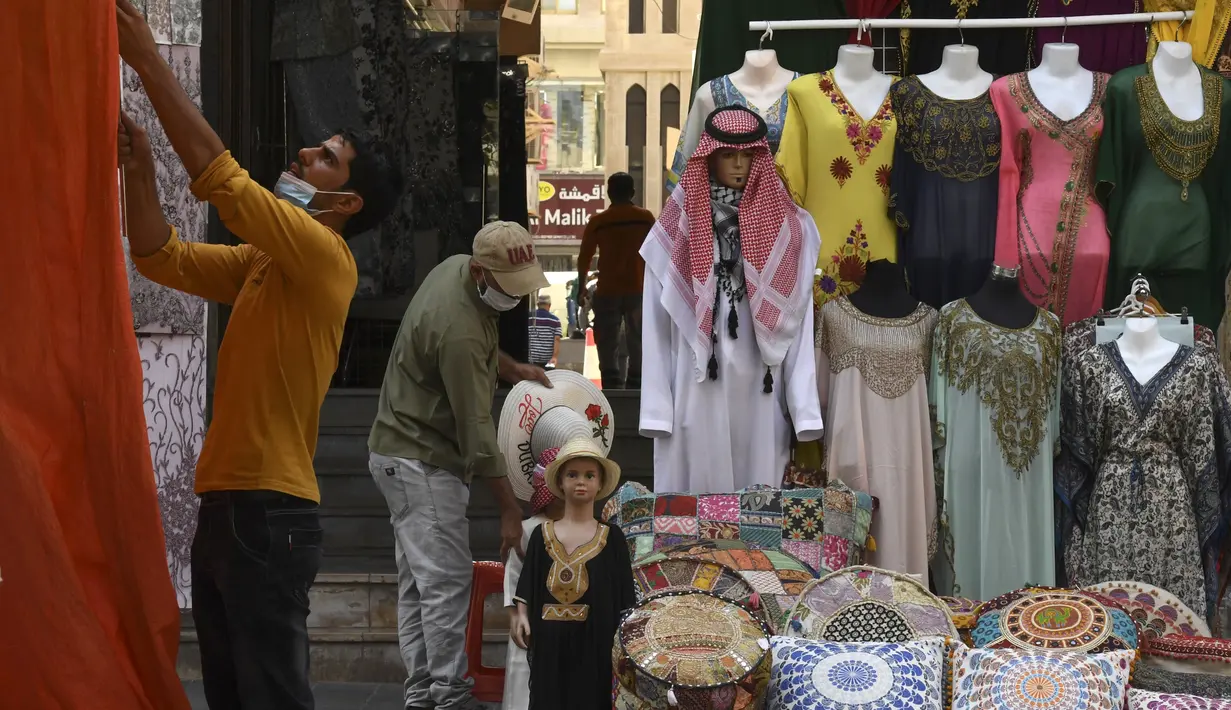 Seorang pemilik toko merapikan barang dagangannya di Deira Souk di kota Emirat Dubai (30/9/2020). (AFP/Karim Sahib)