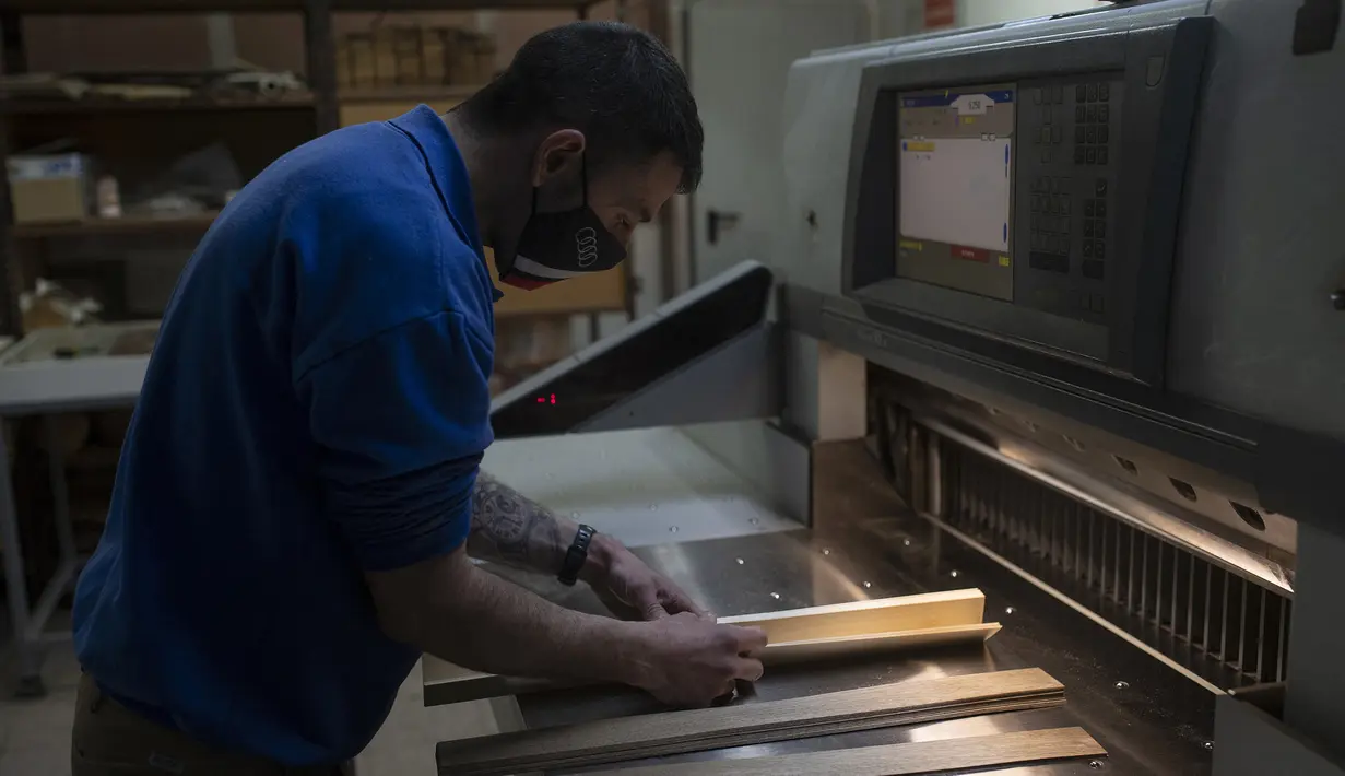 Karyawan Rechapados Ferrer membuat papan catur di La Garriga dekat Barcelona (5/3/2021). Penjualan pembuat papan catur Spanyol itu melonjak sejak ditampilkan di serial Netflix terkenal "The Queen's Gambit". (AFP Photo/Josep Lago)