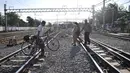 Seorang pria mengangkat sepedanya menyeberangi perlintasan rel kereta api di kawasan Pisangan Baru, Jakarta, Selasa (10/9/2019). Warga nekat menantang maut menyeberangi rel dekat stasiun Jatinegara tersebut lantaran tidak adanya akses jembatan penyeberangan orang (JPO). (merdeka.com/Iqbal Nugroho)