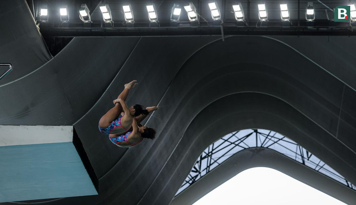 Atlet loncat indah putri Jawa Timur, Gladies Lariesa Garina (kanan) dan Linar Betiliana beraksi pada nomor menara synchro putri Kejurnas Akuatik 2026 yang berlangsung di Stadion Akuatik Gelora Bung Karno, Senayan, Jakarta. (Bola.com/Bagaskara Lazuardi)