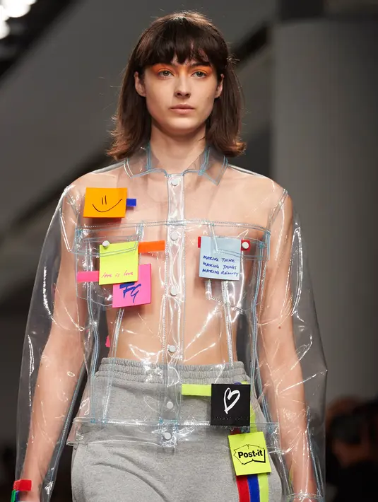 Seorang model berjalan di catwalk mengenakan busana unik label Fyodor Golan edisi Fall/Winter 2017 selama London Fashion Week di London, 17 Februari 2017. Terlihat kertas post-it ditempel pada outerwear transparan berpotongan jaket. (NIKLAS HALLE'N/AFP)