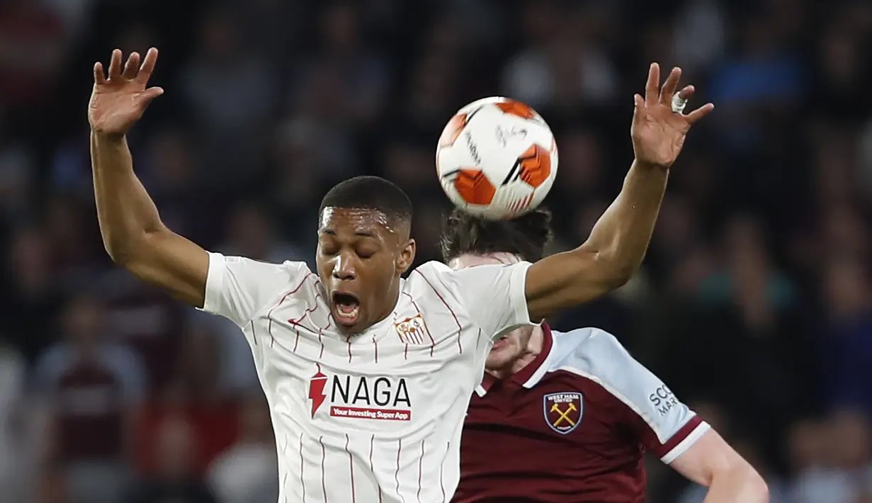 Penyerang Sevilla, Anthony Martial melompat untuk merebut bola dari pemain West Ham, Declan Rice pada pertandingan leg pertama babak 16 besar Liga Europa di stadion Ramon Sanchez-Pizjuan, Spanyol, Jumat (11/3/2022). Sevilla menang atas West Ham 1-0. (AP Photo/Angel Fernandez)