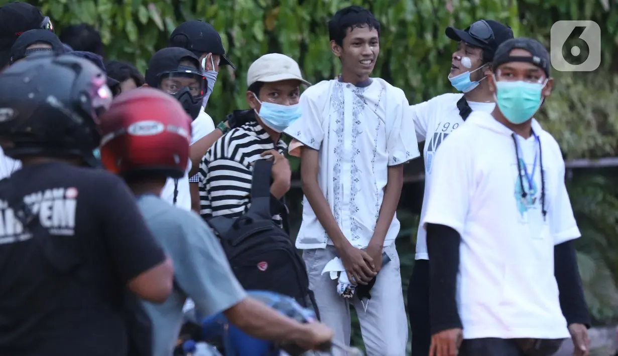 Polisi berpakaian kaus putih memeriksa sekelompok anak muda yang dicurigai terlibat kericuhan di kawasan Tugu Tani, Jakarta, Selasa (13/10/2020). Sejumlah pemuda diamankan polisi karena dicurigai terlibat kericuhan di kawasan Tugu Tani. (Liputan6.com/Helmi Fithriansyah)