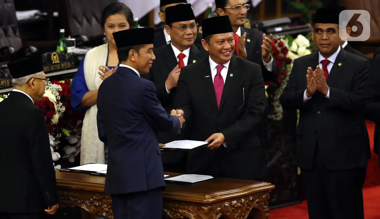 Joko Widodo atau Jokowi (kedua kiri) menyerahkan berkas kepada Ketua MPR Bambang Soesatyo saat dilantik menjadi Presiden RI periode 2019-2024 di Gedung Nusantara, Jakarta, Minggu (20/10/2019). Jokowi dan Ma'ruf Amin resmi menjadi Presiden dan Wakil Presiden RI. (Liputan6.com/JohanTallo)