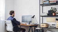 Ilustrasi seorang pria sedang bekerja dengan menggunakan kursi dan meja kantor. (Shutterstock/LStockStudio)