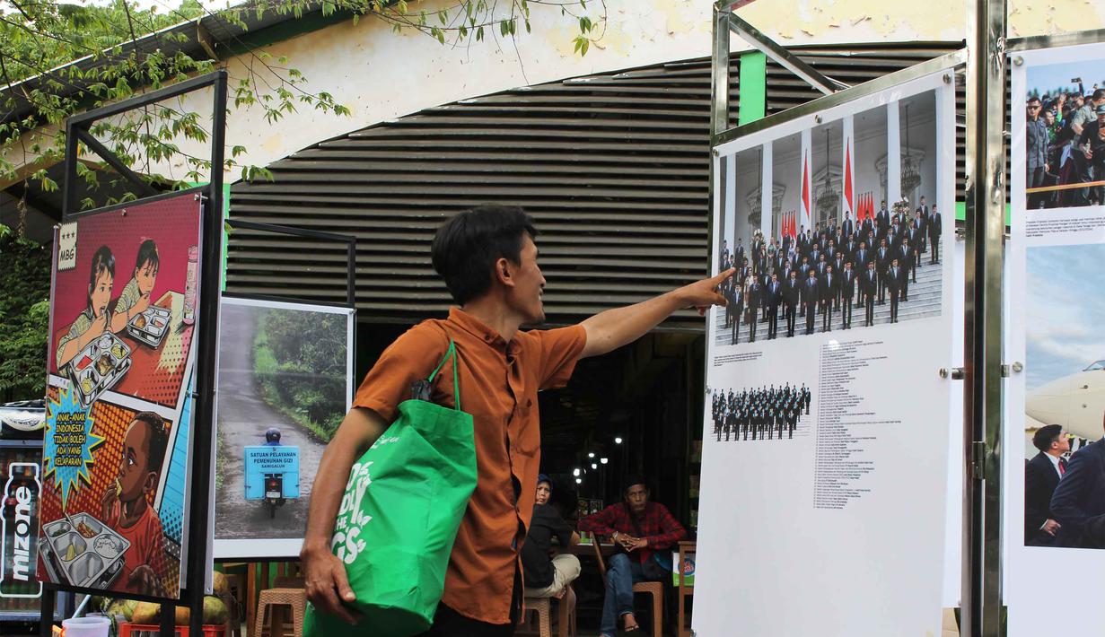Pameran ini diselenggarakan dalam rangka memperingati satu tahun kepemimpinan Presiden Prabowo Subianto dan Wakil Presiden Gibran Rakabuming Raka. Tampak dalam foto, pengunjung menyaksikan karya foto jurnalistik dalam pameran Haluan Merah Putih Roadshow yang digelar di Selasar Kantin Taman Margasatwa Ragunan, Jakarta Selatan, Rabu (24/12/2025). (merdeka.com/magang/Rendi Saputra)