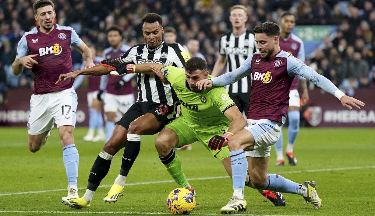 Kiper Aston Villa, Emiliano Martinez, berusaha merebut bola dari pemain Newcastle United, Jacob Murphy, pada laga Liga Inggris di Stadion Villa Park, Birmingham, Selasa (30/1/2024). (Jacob King/PA via AP)